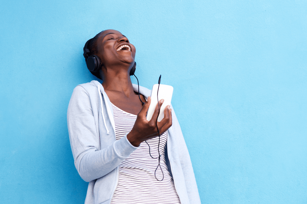 happy-woman-with-smart-phone-and-headphones-by-blu-2021-08-26-23-05-27-utc-min